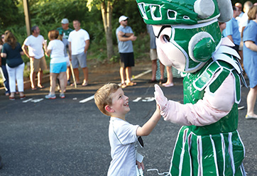 A boy giving the Webb School mascot a high five. Links to Tangible Personal Property