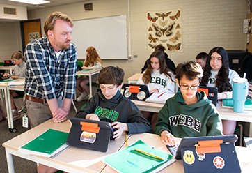 A teacher with students in a classroom. Links to Gifts by Will