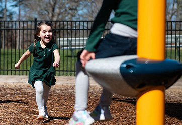 A little girl running to someone at a playground. Links to Gifts That Pay You Income