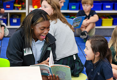 A teacher helping a student in class. Links to Gifts from Retirement Plans