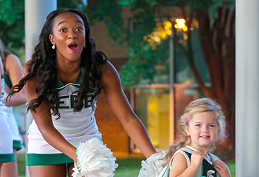 A cheerleader with a little girl. Links to Gifts of Appreciated Securities