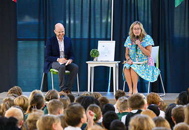 Two people on a stage speaking to a crowd. Links to Beneficiary Designations