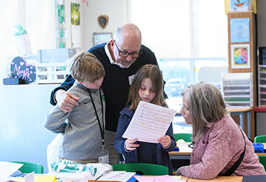 Two teachers helping a couple of students. Links to Gifts of Cash, Checks, and Credit Cards